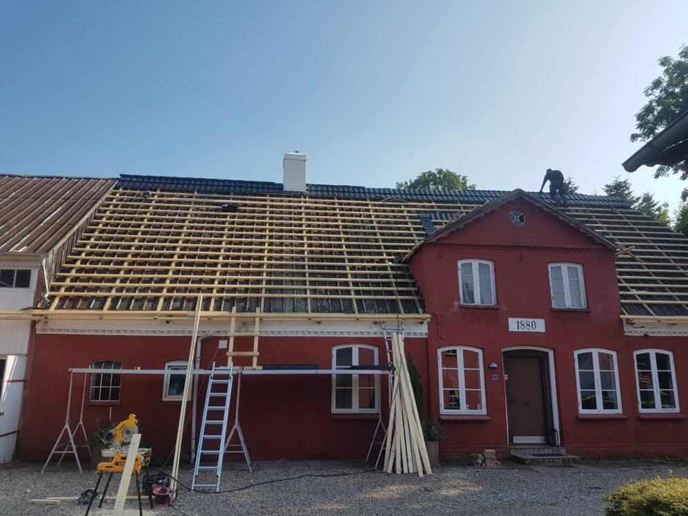 Billedet fremviser en nyt Metrotile ståltag, som installeres over det eksisterende tag på en historisk landejendom nær Fyn.